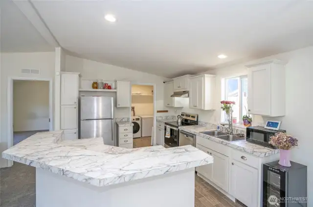 The kitchen boasts a new stainless steel stove/oven, with a conveniently located utility room just steps away.