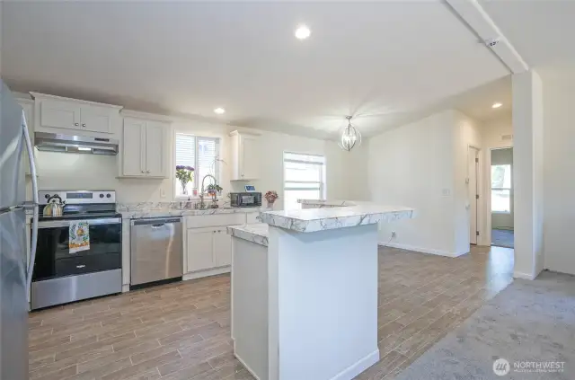 Another angle of the island kitchen, showcasing the open flow into the dining area.