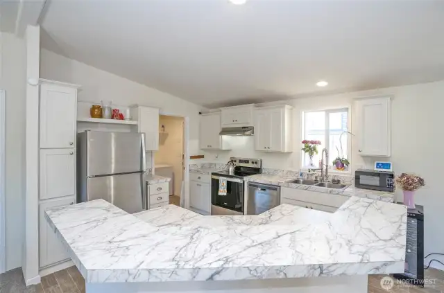 The island provides generous counter space for cooking, dining, and entertaining.