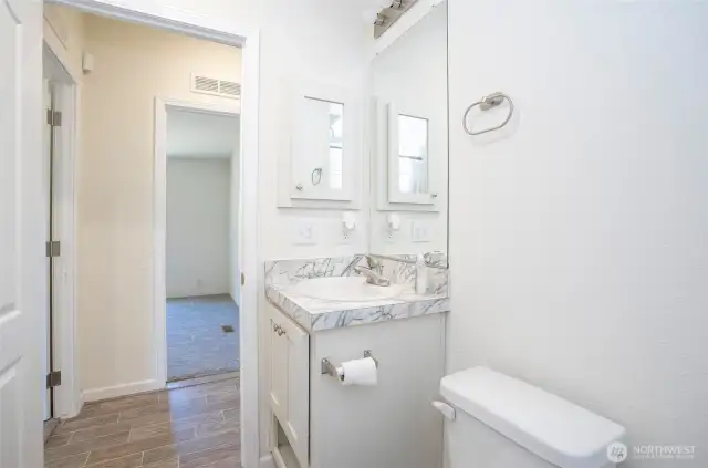 Looking from the guest bathroom into the hallway, you’ll notice the beautiful laminate flooring.