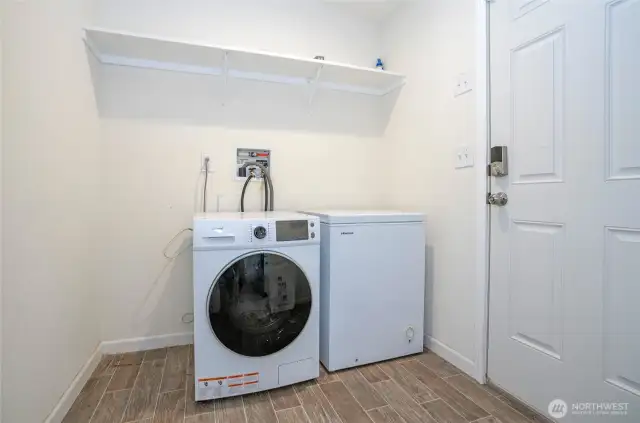 Convenient utility room just off the kitchen, offering extra shelving and direct outdoor access.