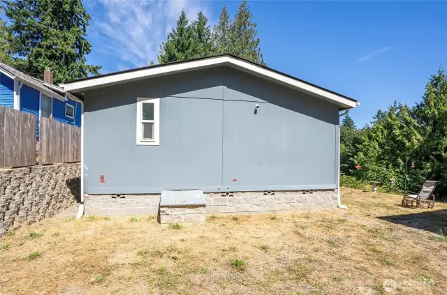 Back of the home with a side yard conveniently located to the right.