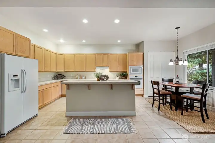 Abundant counters, plenty of cupboards, and a breakfast bar with stool seating makes this kitchen functional and wonderfully social. A cozy eating area adjoins offering the perfect spot for meals or morning coffee.