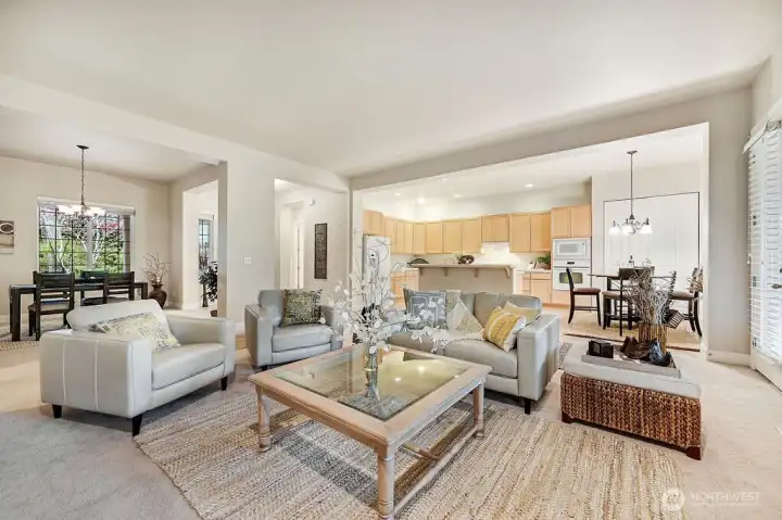 This generous living room invites relaxation and makes hosting a small gathering effortless. Large windows fill the space with natural light, creating a warm and welcoming atmosphere.