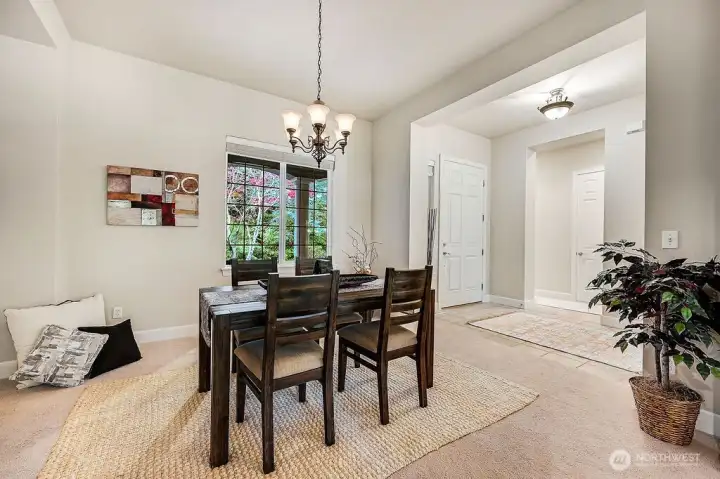 The dining room invites relaxation and makes hosting a small gathering effortless. Large windows fill the space with natural light, creating a warm and welcoming atmosphere.