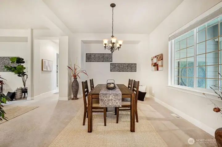 A versatile dining space with generous windows framing the front porch and surrounding greenery, plus ample wall space for a hutch or your own design touches.