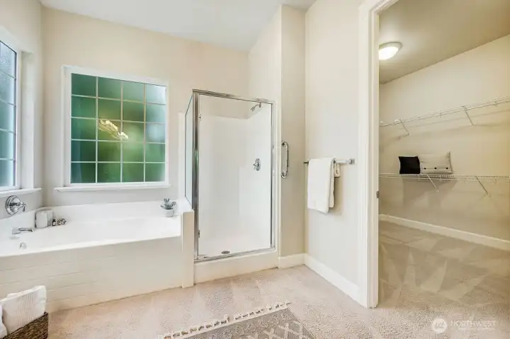 This ensuite combines style and function with a tub, separate shower, and a peek at the generous walk-in closet—perfect for convenience and organization.
