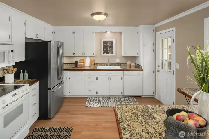 Spacious eat-in kitchen with updated fridge and it's own entrance to patio