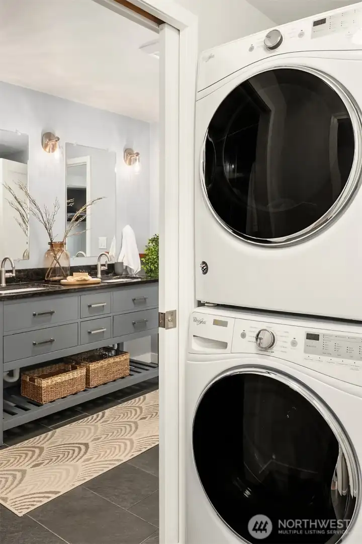 Laundry with newer washer and dryer, pocket door to primary bath for privacy