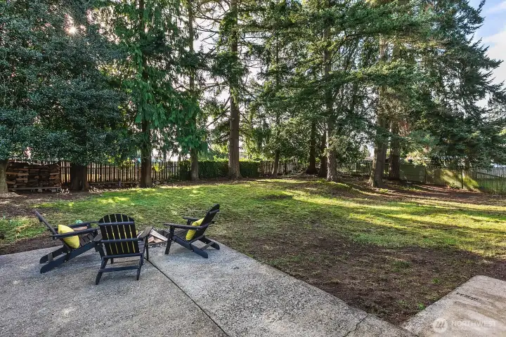 Spacious, fully fenced backyard with DADU potential, firepit area, wooded oasis offering ultimate privacy.