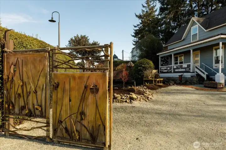 Handcrafted artistic gates set the tone for this distinctive and welcoming property.