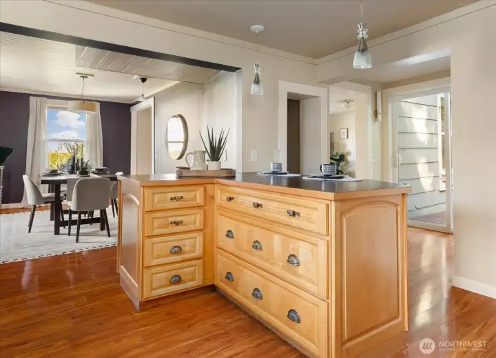 Spacious kitchen with warm wood cabinetry, generous island storage, and open sightlines to the dining area.