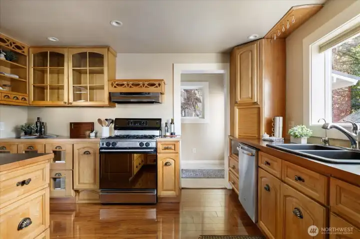 Functional kitchen with gas range, ample cabinetry, and a large central island for cooking, gathering, and casual dining.