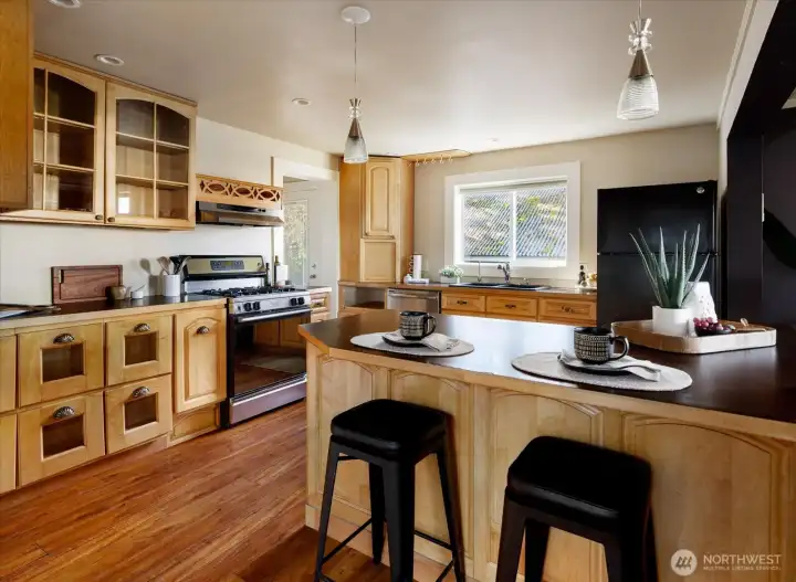 The kitchen feels welcoming and easy to gather in, with warm wood cabinetry, an island for casual conversation, and space to cook while staying connected to the rest of the home.