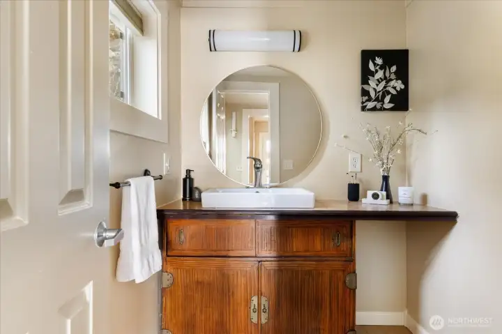 A conveniently located powder room brings a subtle Zen-inspired calm to the space, blending function with quiet character.