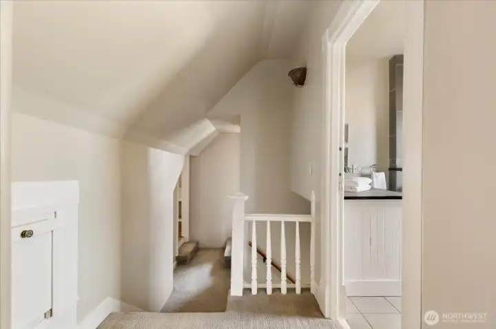 The upstairs landing connects bedrooms and bath while maintaining the cozy character of the home’s original architecture.