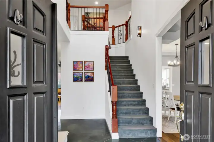 Inviting entry with high ceilings and staircase detail