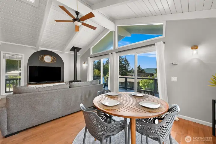 Vaulted wood ceilings and expansive windows bring natural light into this open-concept living and dining space with Lake Whatcom views beyond.
