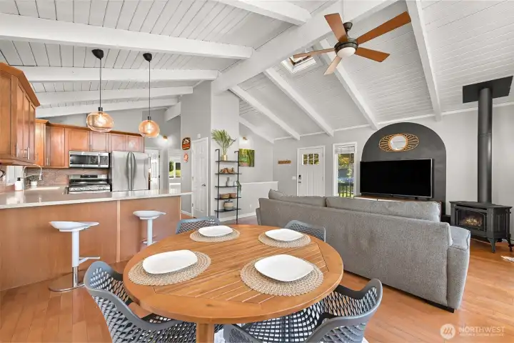 Vaulted wood ceilings and expansive windows bring natural light into this open-concept living and dining space with Lake Whatcom views beyond.
