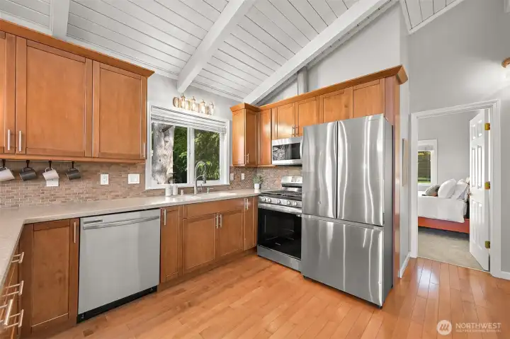 Kitchen features quartz-style counters, stainless appliances, and abundant storage with a warm modern feel.
