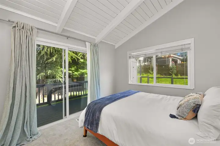 Secondary bedroom with large windows, vaulted ceilings, and peaceful neighborhood outlooks.