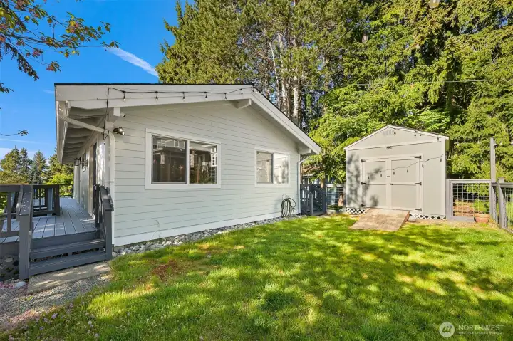 Backyard includes lawn space, storage shed for golf cart, bikes and more, and mature trees for privacy and shade.