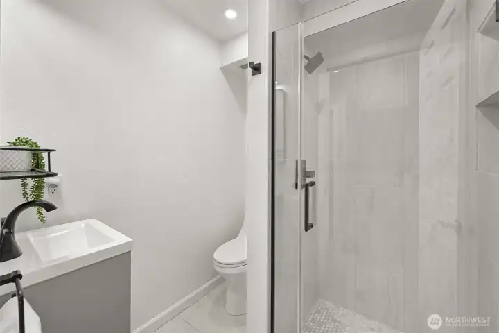 Remodeled primary bath with walk-in tile shower and clean, modern finishes.