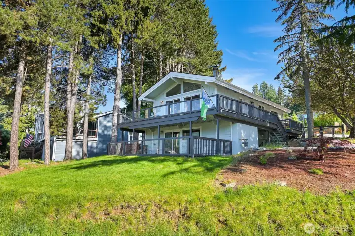 Exterior highlights include multiple outdoor living spaces, updated landscaping, and a setting surrounded by mature trees.