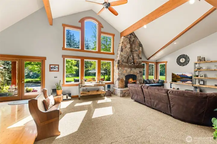 Spacious and stylish living space with room to spread out or entertain a crowd is crowned with an airy vaulted ceiling with handsome beams