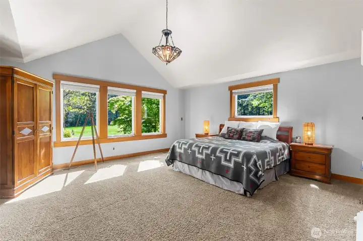 Main floor spacious primary suite with views to the rear yard, airy vaulted ceiling and ensuite bath