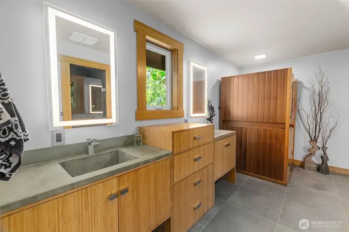 Primary bath features dual vanities with handsome fit and finish, a sauna and large walk in shower