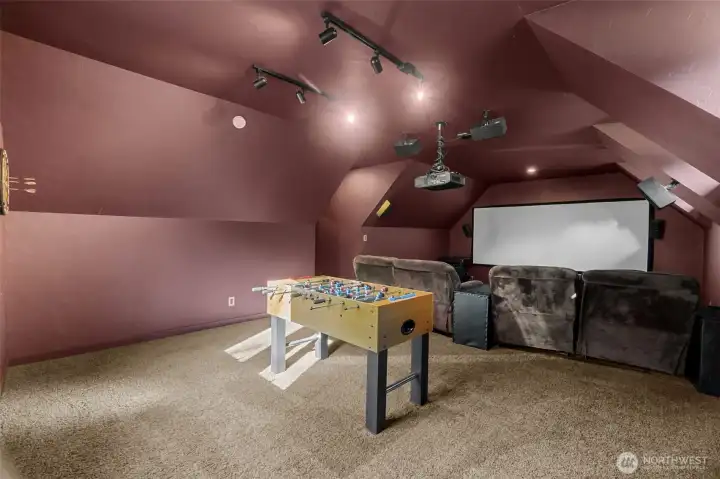 Dedicated media room has all the things....game table space, projector and screen and surround sound