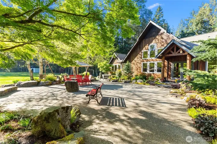 Large and private rear patio features mature, native landscaping, custom hard scape, fire pit and private hot tub area