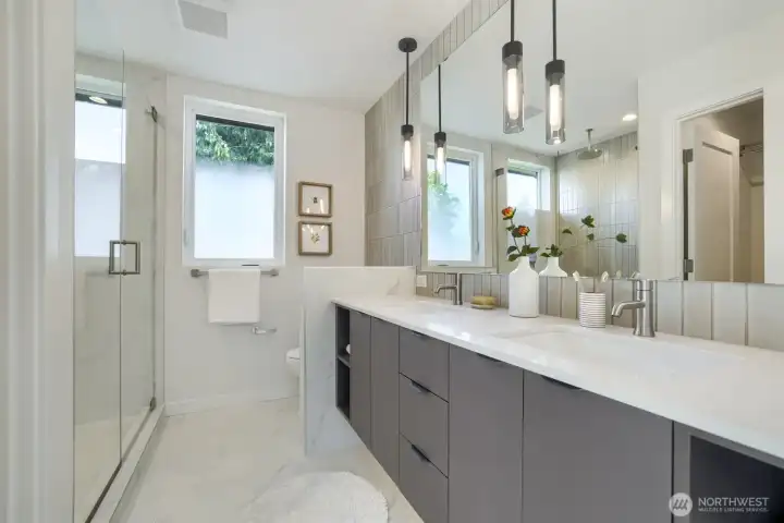 The primary bath has a luxurious bath, double sinks, and rain shower head.