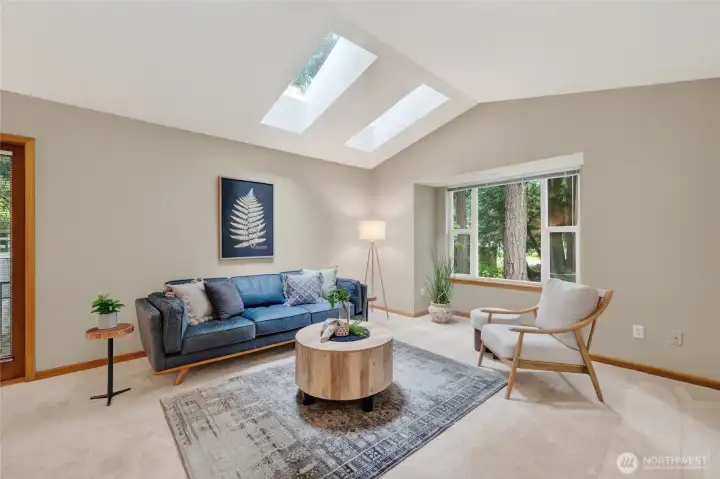 The living room is spacious and looks out to the towering evergreens to the front and side yard.