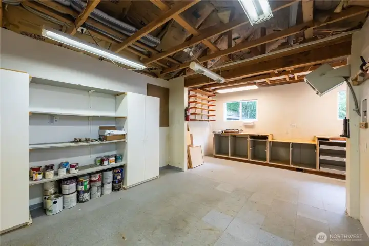 The work shop is spacious, has a vinyl tile floor and heat as well as a lot of light and storage.