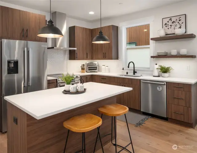 Quartz countertops with full-height tile backsplash and Elica wall hood with extension to ceiling.