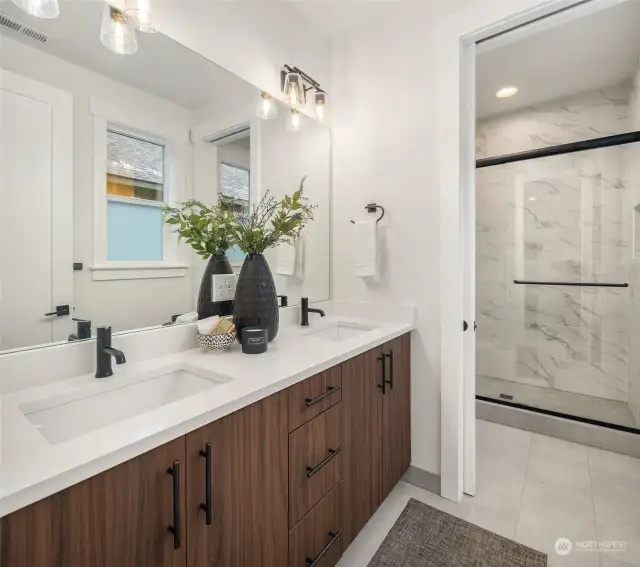 Quartz countertops with 4" quartz backsplash and tile shower.