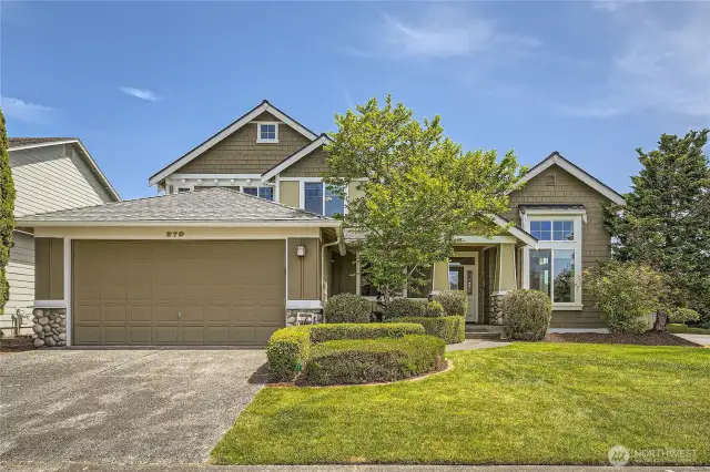 Beautiful two-story home located at 270 Kitsap Ave NE, Renton. The property boasts great curb appeal with its well-manicured landscaping, lush green lawn, and neatly trimmed hedges. The exterior features a harmonious blend of earthy tones, stone accents, and craftsman-style architectural details. A large 3-car tandem garage anchors the left side of the home, while a charming covered entryway framed by columns and greenery welcomes you inside. Tall windows bring in an abundance of natural light, and a mature tree adds a touch of privacy and character to the front yard. Set against a clear blue sky, this home offers a warm and inviting first impression.