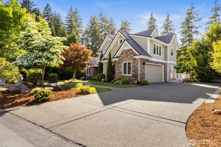 The large driveway offers ample parking and smooth access to the attached garage.
