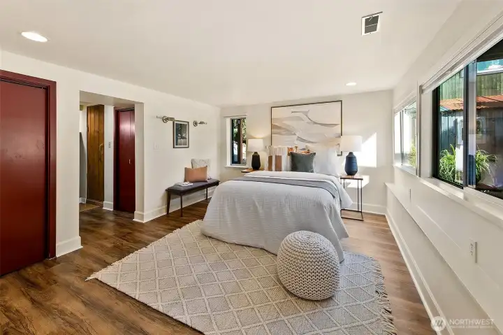 Lovely large primary bedroom. The 3/4 bath and cedar sauna are adjacent to the bedroom. There are also two separate closets.. a fireplace, and a calming view out to the garden.