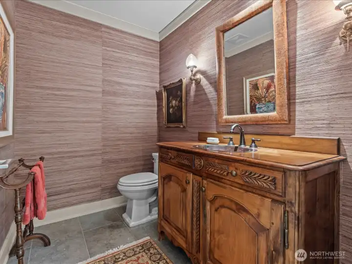 Powder room with antique cupboard and antique sconces.