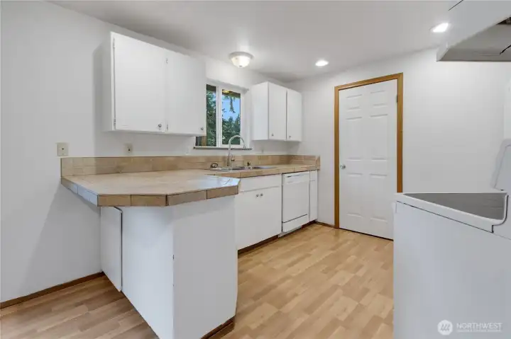 Convenient kitchen with eating bar, all appliances, pantry and bright window which looks out to your private backyard.  Abundant kitchen storage.