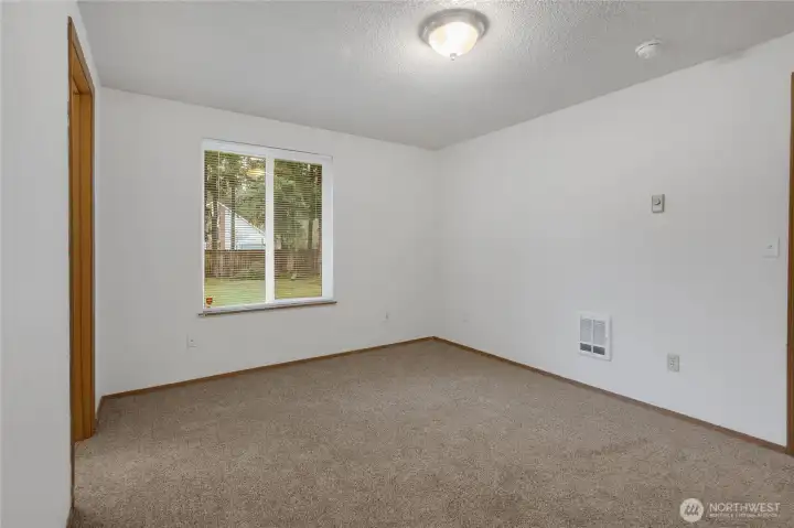Primary bedroom looks out to private fully fenced backyard