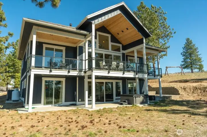 View of back of home wtih all windows, decks and architecture design