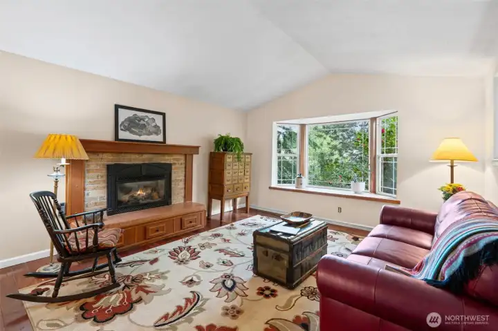Vaulted ceilings, bay window, and cozy gas fireplace create a warm and inviting main living space.