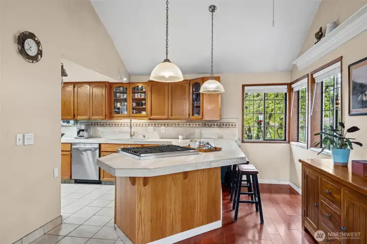 JennAir gas range, counter seating, and soaring cathedral ceilings make this kitchen the heart of the home.