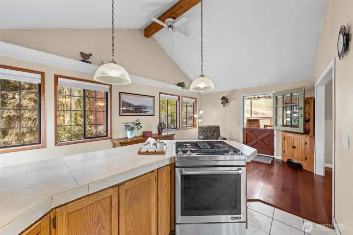 Kitchen cooktop bar overlooking the cozy seating area with Dutch door access to the covered outdoor living space.