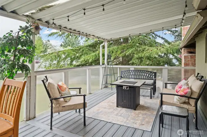 Extended outdoor deck seating area surrounded by peaceful greenery.