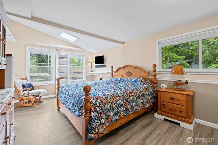 Spacious primary bedroom with skylight and beautiful natural light.